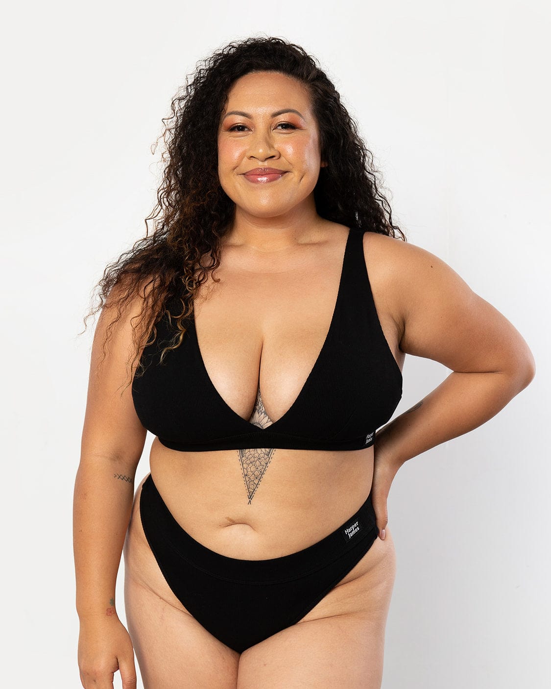 Our confident model is showcasing our always ordered Plunge bra set in midnight black matching this up with a black thong