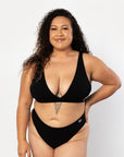 Our confident model is showcasing our always ordered Plunge bra set in midnight black matching this up with a black thong